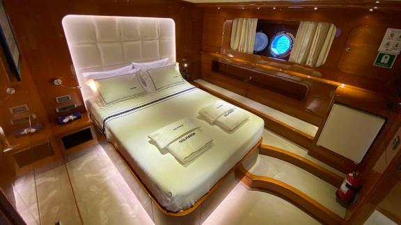 Comfortable cabin with double bed and porthole on yacht Gül Maria